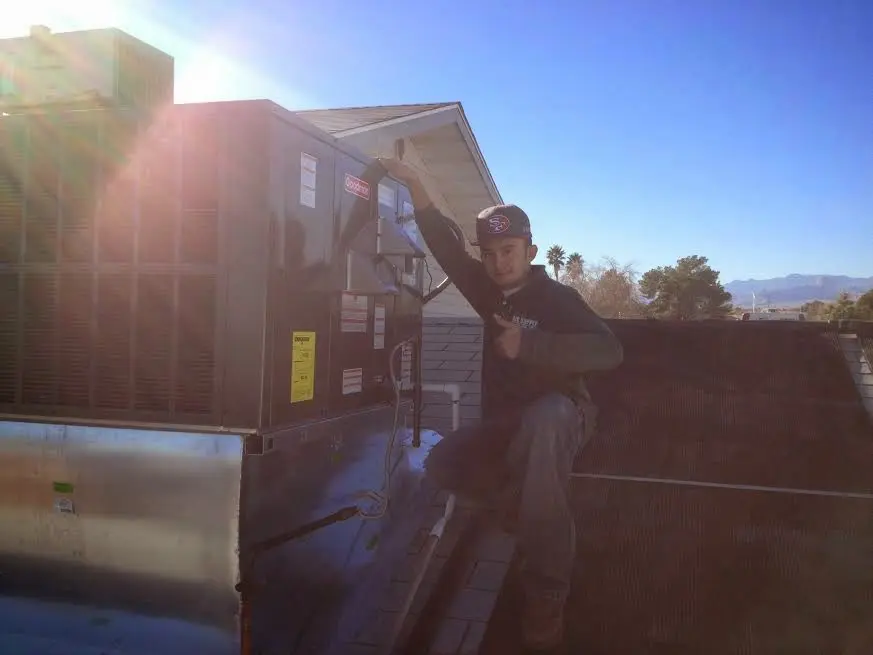 HVAC technician performing AC Tune-Up on a rooftop unit in Rib Mountain